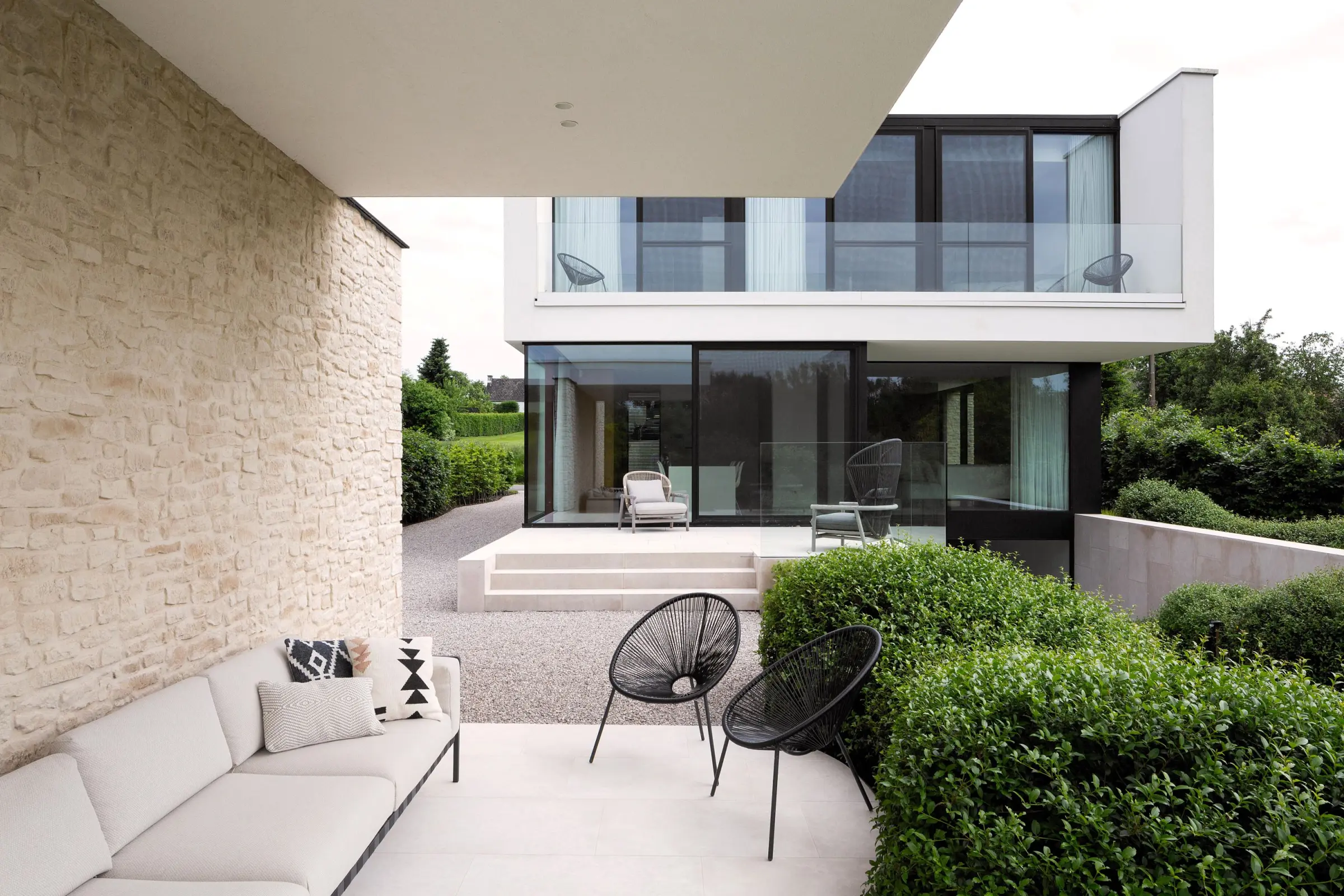 muur in steen en achteraan villa met wit sierpleister