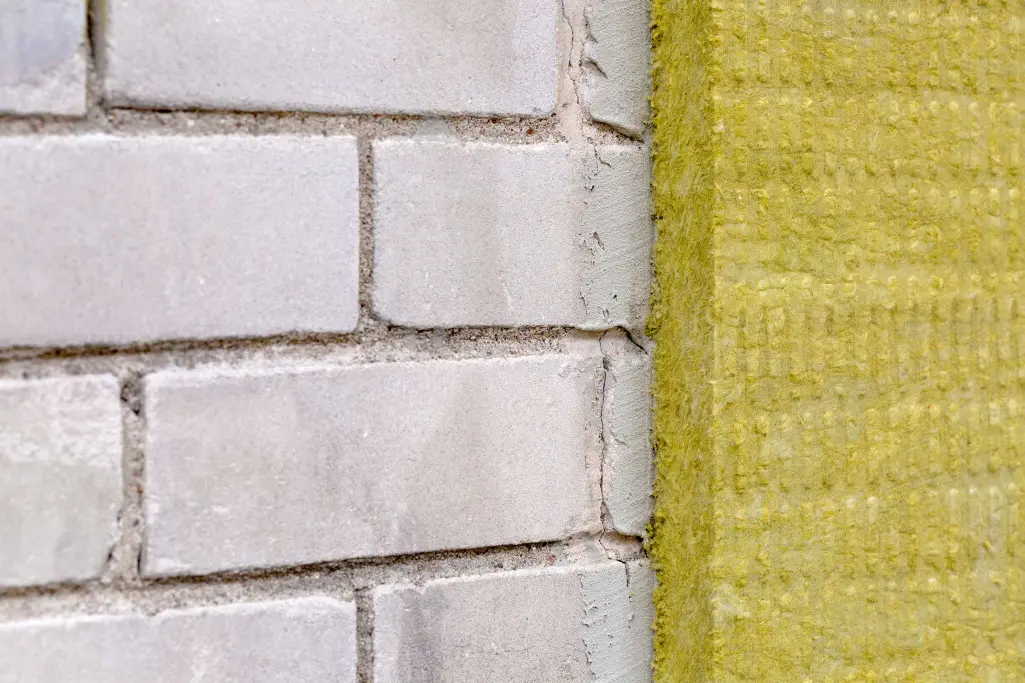 De buitenmuur van een gebouw is geïsoleerd met minerale wol.